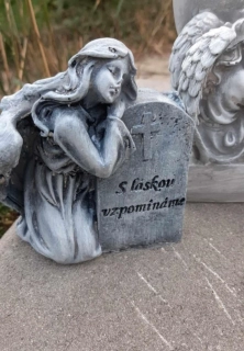 Dívka klečící u náhrobního kamene